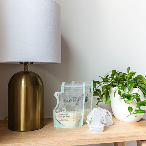 Motif Medical Pump-To-Bag Adapter shown with Motif Medical Breastmilk Storage Bags in a home setting