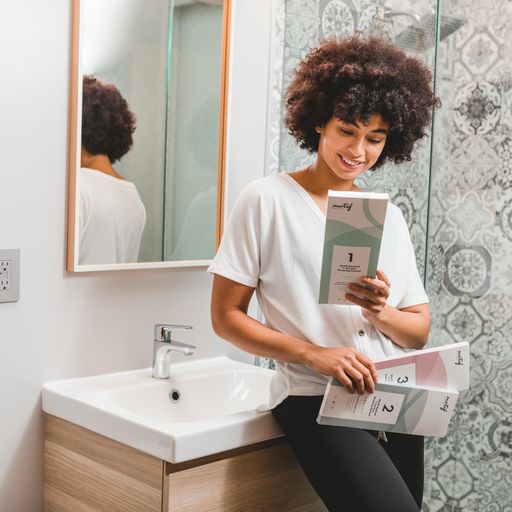 Woman standing in the bathroom holding Motif Medical C Section Bandage System Stages 1,2,3