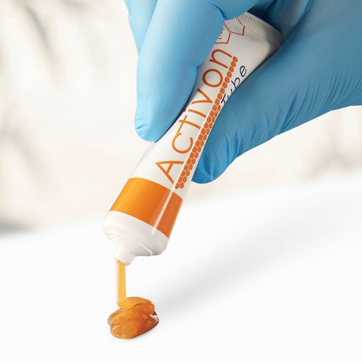 Activon Honey Tube being squeezed to show product being dispensed from the tube