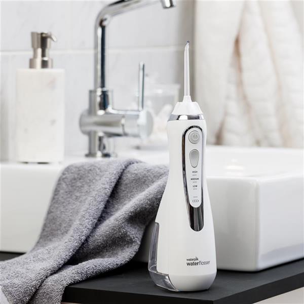 Waterpik Cordless Advanced Water Flosser placed on a bathroom counter near the sink